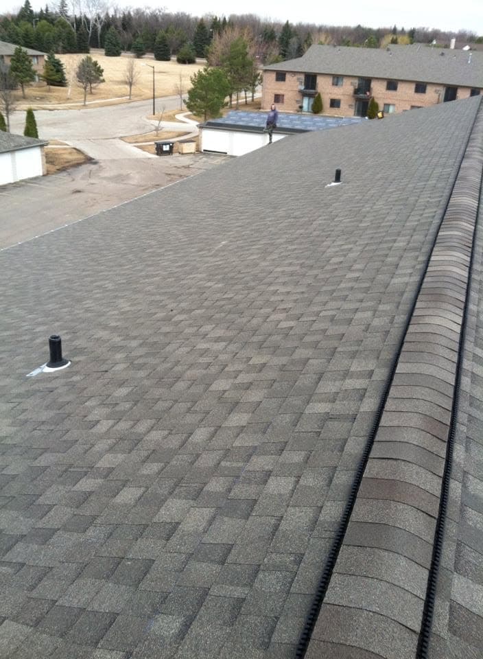 Wide shingle field on an apartment building with vents set in place