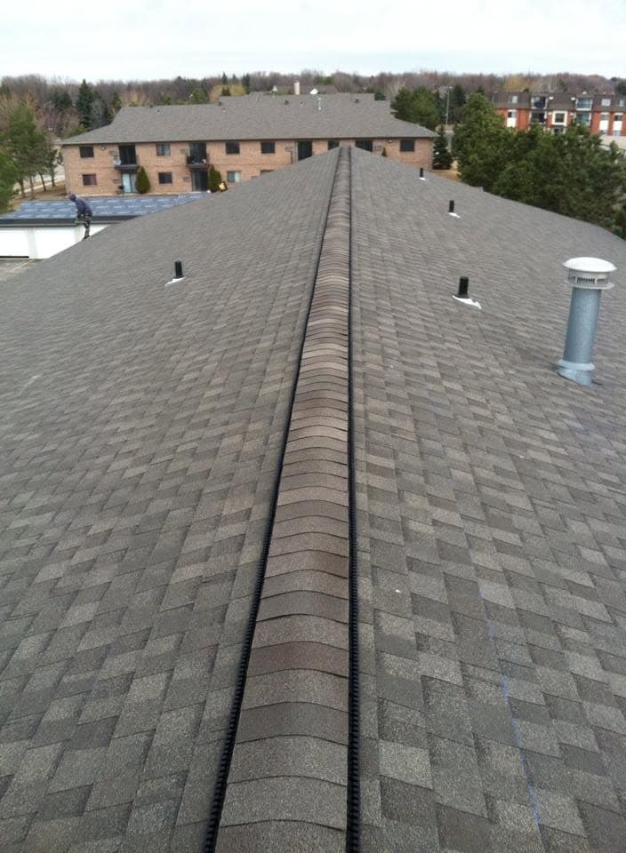 Ridge-line view down an apartment building roof with the complex beyond