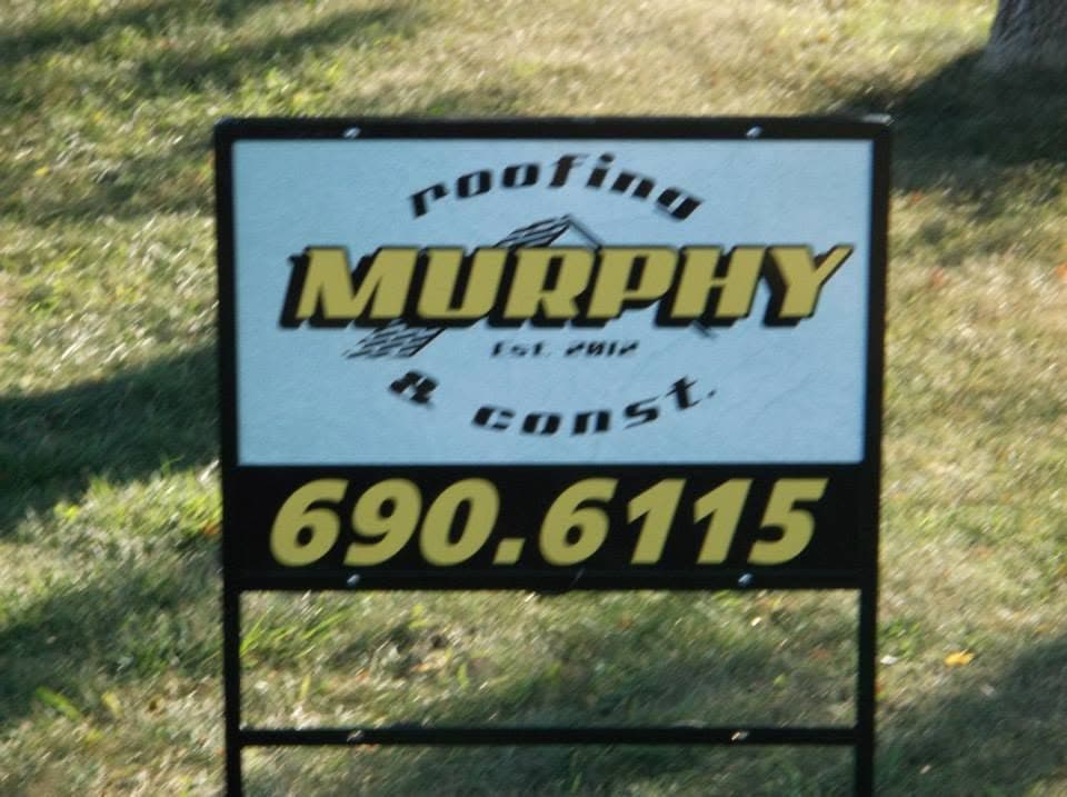 A Murphy Roofing and Construction yard sign reading EST. 2012, planted in a lawn at a job site