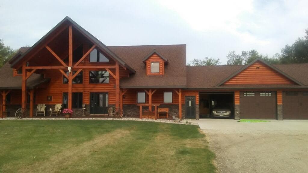 Log lodge-style home with a completed brown shingle roof