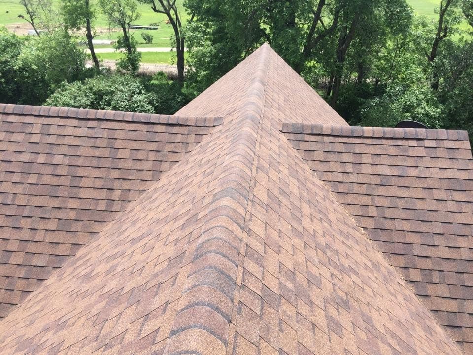 Red-brown shingle courses meeting at a hip peak