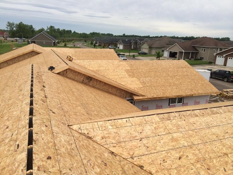Fresh sheathing panels laid over the rafters of a roof