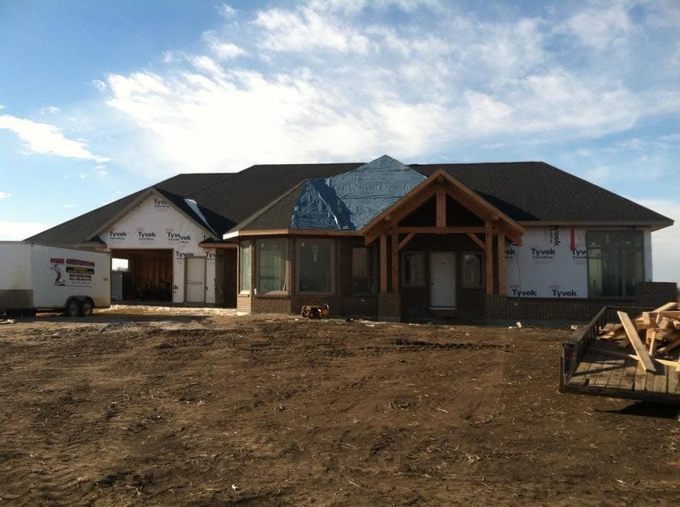 Timber-frame home under construction with its roof deck on