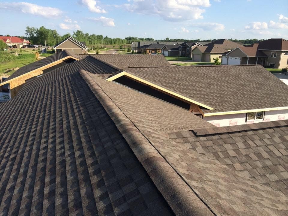 Dark shingle ridge running the length of a townhome row