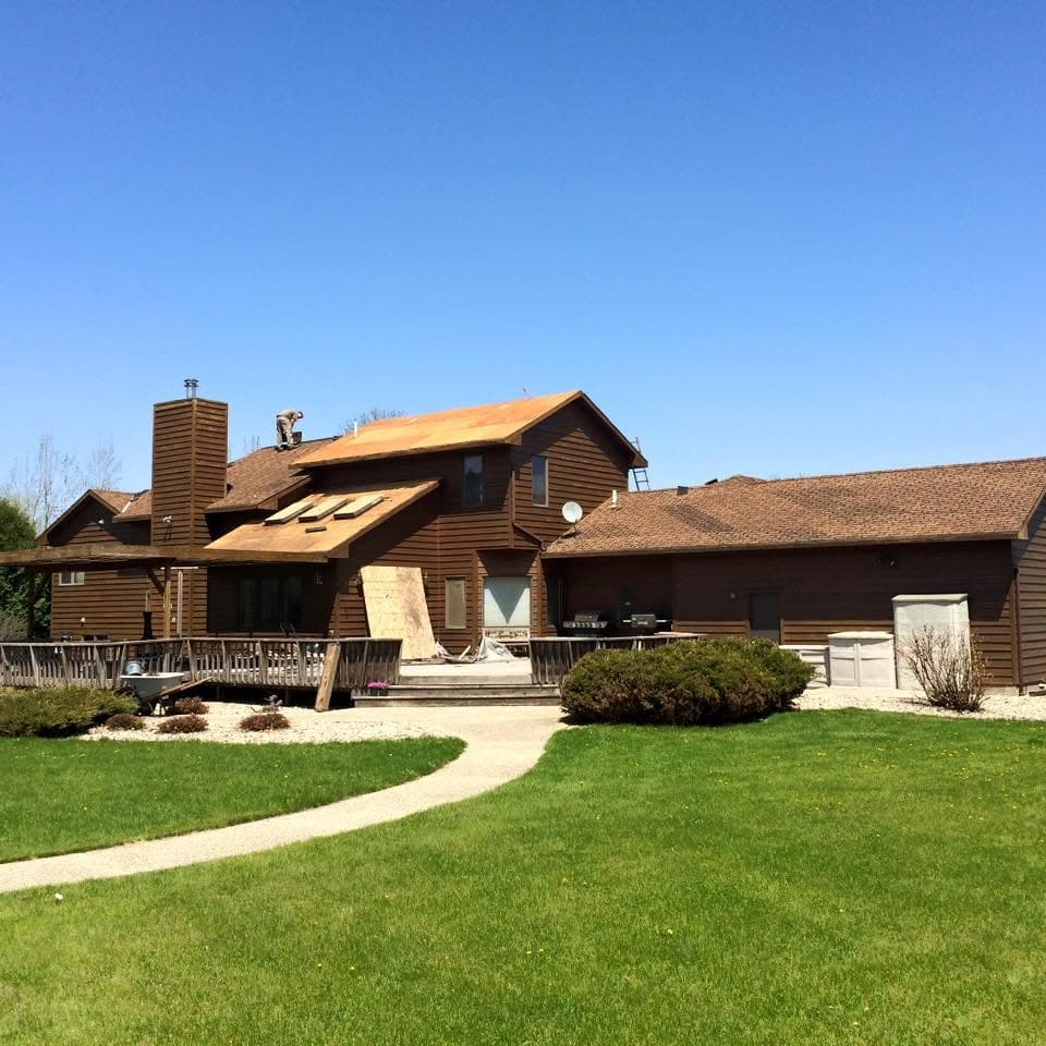 Two-story home with a chimney getting a full re-shingle