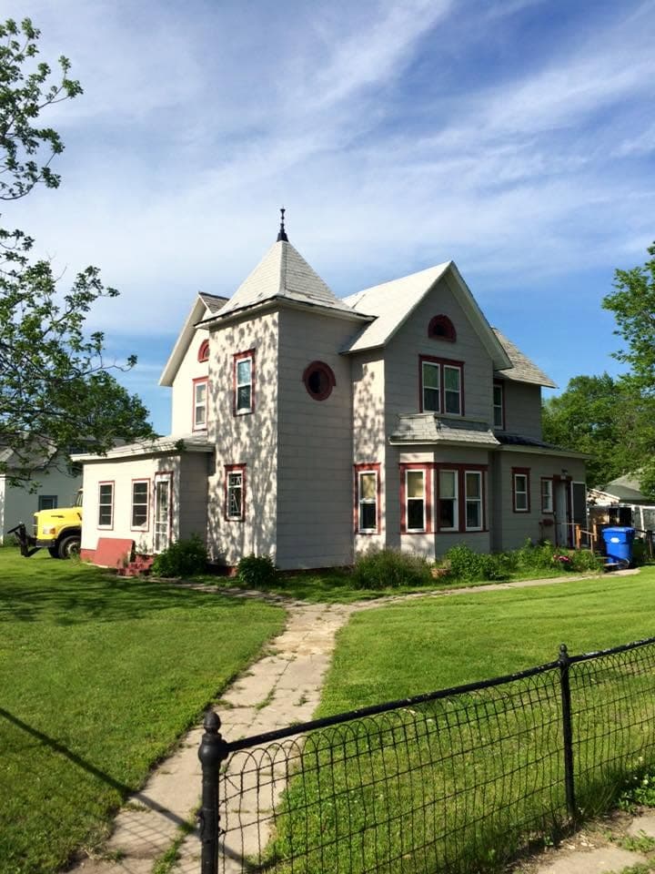 Turreted two-story house wearing a new gray shingle roof