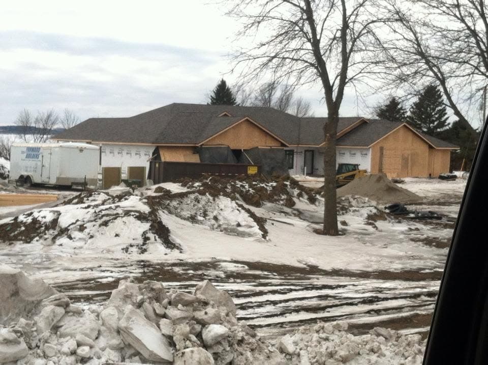 Ranch home in winter with snow banks pushed clear of the drive